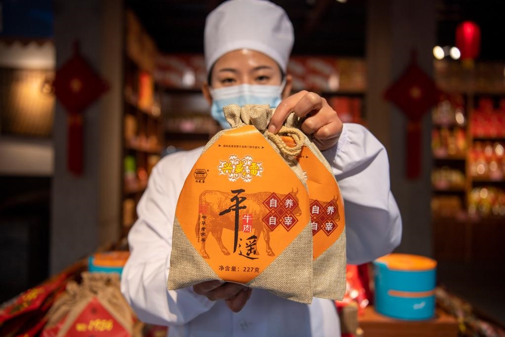 1月27日，在平遙古城南大街的一家平遙牛肉店內，工作人員展示一款牛肉產(chǎn)品。新華社記者 楊晨光 攝