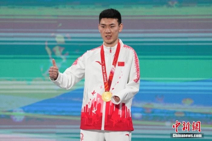 3月6日，梁景怡在延慶頒獎廣場領(lǐng)獎臺上豎起大拇指。當(dāng)日，在國家高山滑雪中心舉行的北京2022年冬殘奧會殘奧高山滑雪男子超級大回轉(zhuǎn)—站姿決賽中，中國選手梁景怡奪得冠軍。 <a target='_blank' href='/'>中新社</a>記者 楊華峰 攝