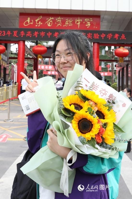 6月7日高考首日，山東67萬考生走進考場，拼搏逐夢。在山東省實驗中學(xué)考點，考生進考場前手捧向日葵花拍照留念，寓意“一舉奪魁”。人民網(wǎng)記者 劉祺攝