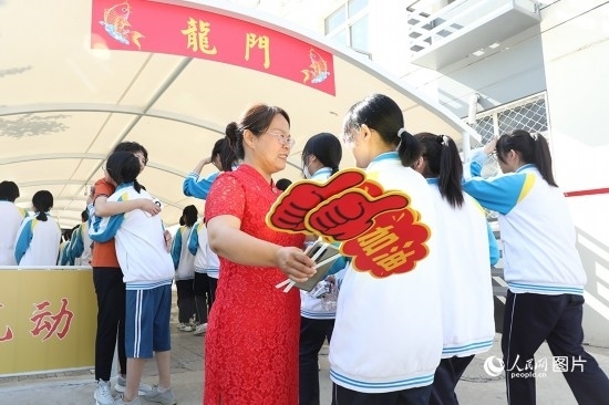 6月7日一早，雄安新區(qū)安新中學(xué)老師在給同學(xué)們加油鼓勁兒。人民網(wǎng) 李兆民攝