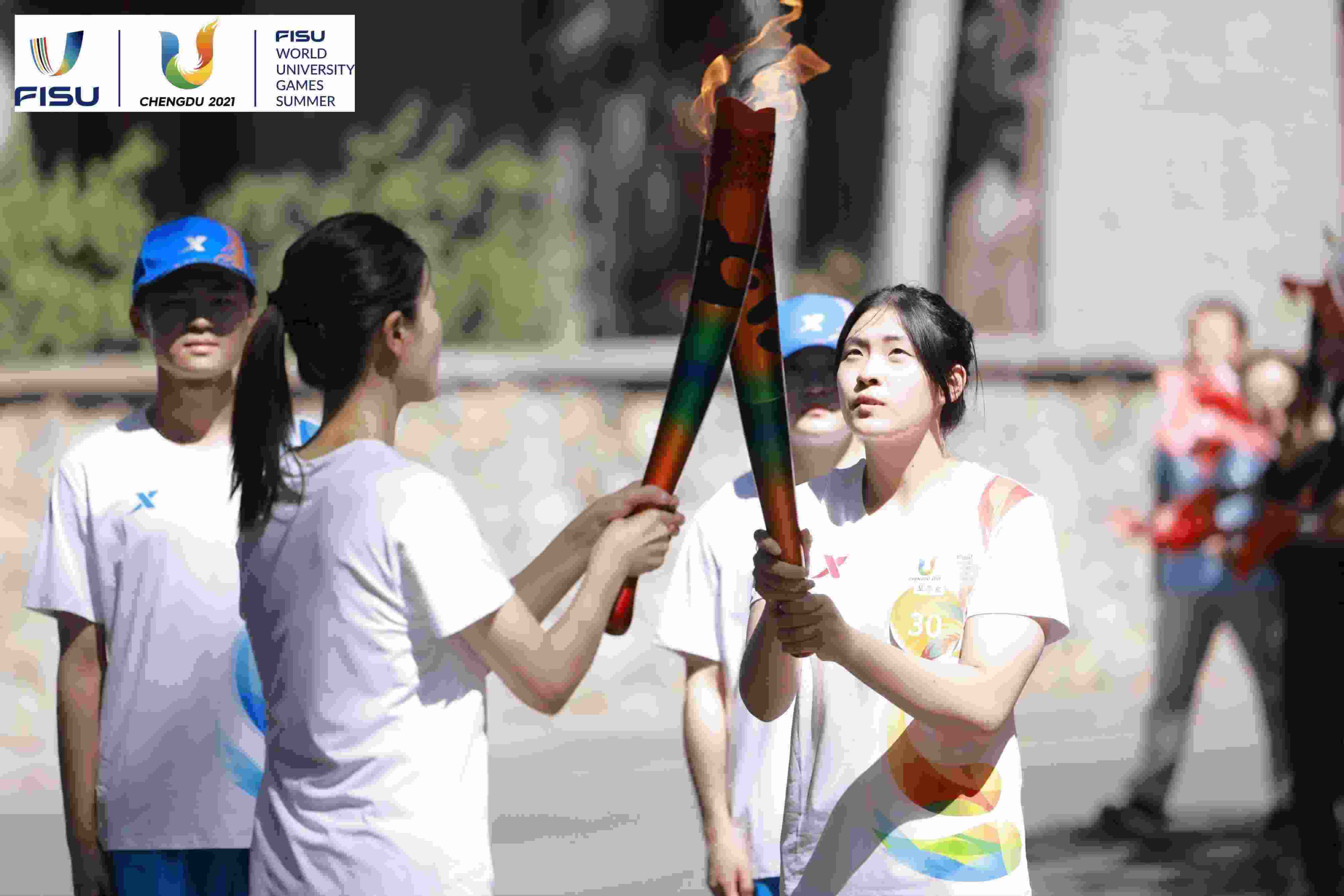 兩名大運(yùn)會(huì)火炬手進(jìn)行火炬?zhèn)鬟f。 圖片來(lái)源：成都大運(yùn)會(huì)執(zhí)委會(huì)供圖