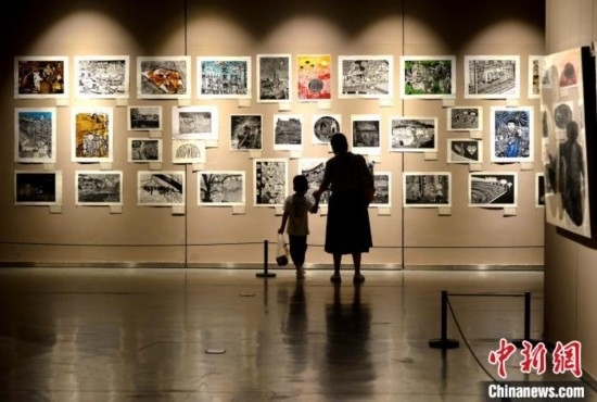 圖為家長帶著孩子參觀展覽。呂明 攝