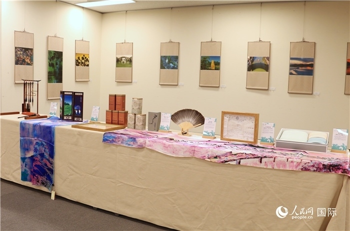 現(xiàn)場(chǎng)展出的馮學(xué)敏攝影作品與湖州市特色工藝品。（人民網(wǎng) 許可攝）