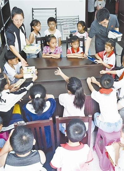  圖④：法院干警為留守兒童發(fā)放暑假讀物。