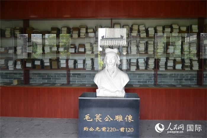 河間詩經(jīng)齋毛萇雕像。雕像后書櫥中陳列的是歷代各版本《詩經(jīng)》及譯本。 人民網(wǎng) 趙昭攝