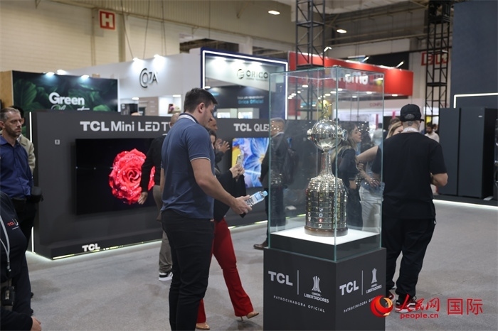 參觀者在TCL展臺前觀看南美解放者杯獎杯，據(jù)介紹，TCL是南美解放者杯（2023—2026賽季）全球官方合作伙伴。（人民網記者 時元皓攝）