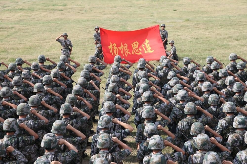 ↑“楊根思連”官兵執(zhí)行任務(wù)前向連旗宣誓（資料照片）。新華社發(fā)