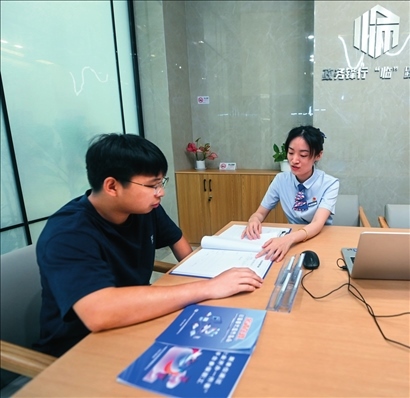 在杭州市臨安區(qū)政務(wù)服務(wù)中心的“為企服務(wù)中心”，黨員志愿者（右）解答企業(yè)主的疑問(wèn)（2023年7月7日攝）。徐昱攝/本刊