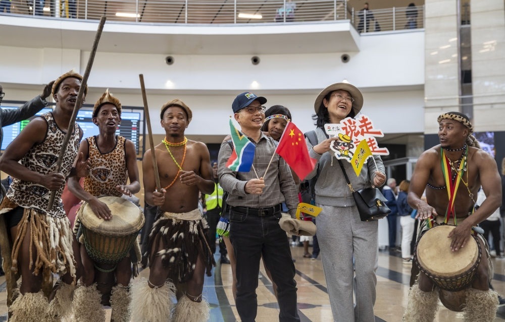 在南非約翰內(nèi)斯堡坦博國(guó)際機(jī)場(chǎng)，南非舞蹈演員歡迎中國(guó)試點(diǎn)恢復(fù)出境團(tuán)隊(duì)旅游后首批抵達(dá)南非的中國(guó)游客（2023年3月29日攝）。