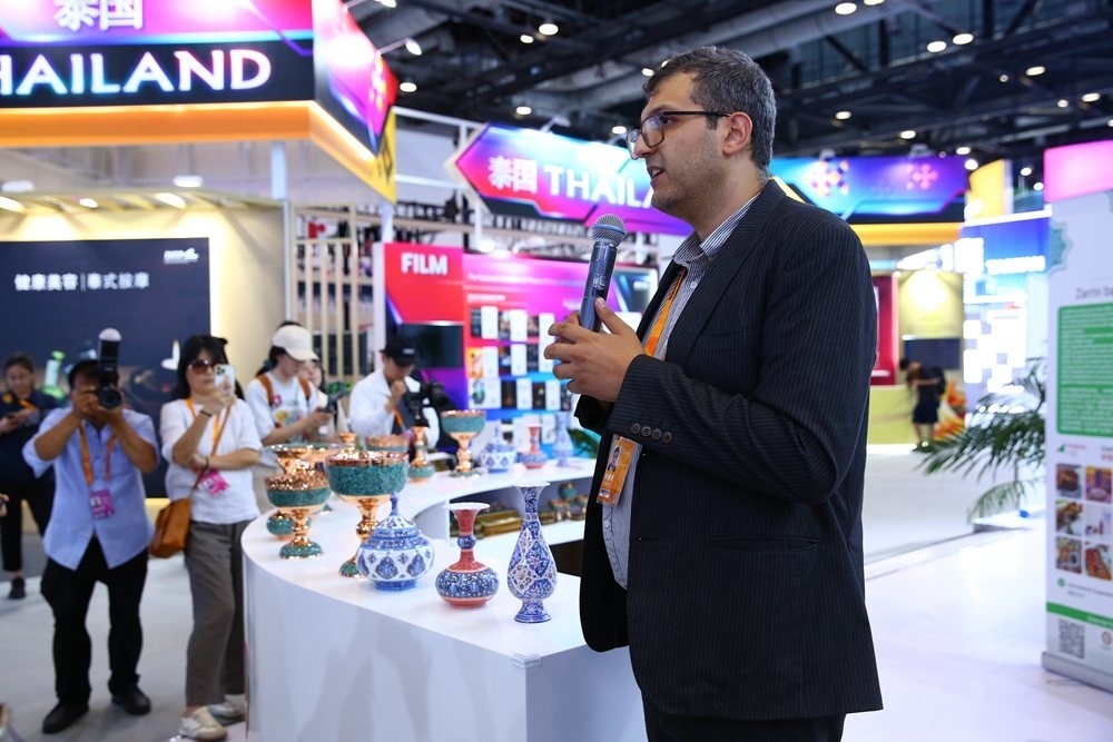 9月1日，參展商在國家會議中心向媒體記者介紹展臺信息。新華社記者 孫瑋彤 攝