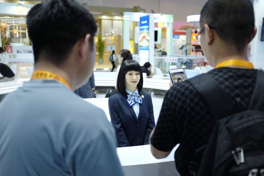 9月1日，媒體記者在國家會議中心與服務(wù)機(jī)器人互動。新華社記者 劉夢琪 攝