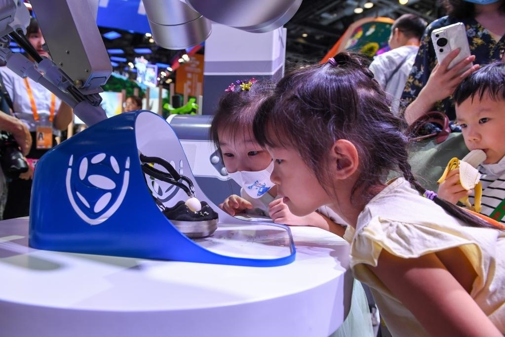 9月3日，幾名小朋友在國家會議中心觀看單孔腔鏡手術(shù)機(jī)器人展示。新華社記者 鞠煥宗 攝