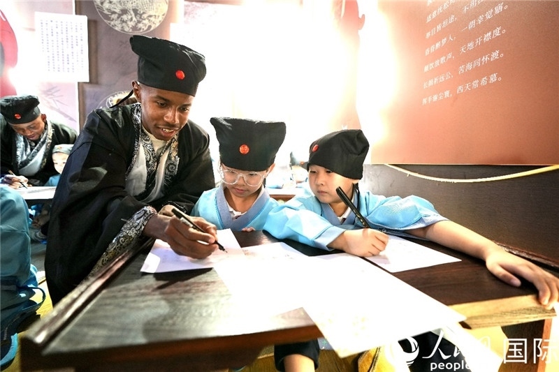 圖為選手與同學(xué)們一起寫書法。人民網(wǎng) 盧鵬宇攝