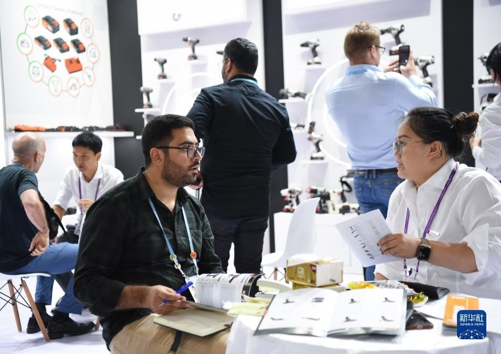 10月15日，在一家電動工具展臺，外國采購商在洽談業(yè)務(wù)。新華社記者 鄧華 攝