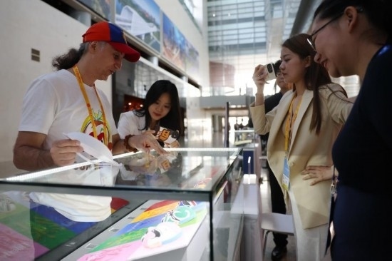 10月16日，參會(huì)記者在“一帶一路”國際合作高峰論壇新聞中心參觀展示的中國非物質(zhì)文化遺產(chǎn)展品。新華社記者 陳斌 攝