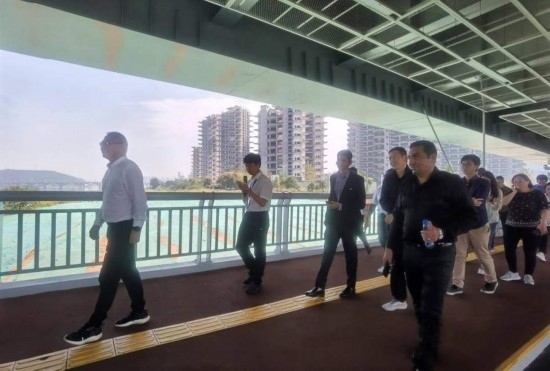 10月24日，2023“一帶一路”媒體合作論壇聯(lián)合采訪團(tuán)團(tuán)員走在清水塘大橋景觀通道上。本報(bào)記者 常雯宜攝