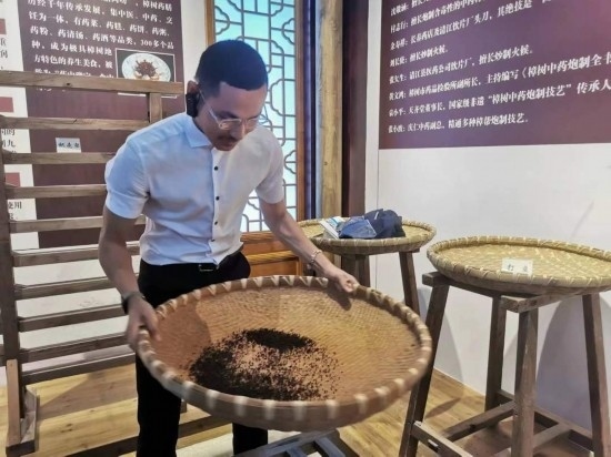 2023“一帶一路”媒體合作論壇聯(lián)合采訪團(tuán)團(tuán)員在非遺文化展示館體驗(yàn)中藥炮制技藝。（本報(bào)記者 黃超攝）