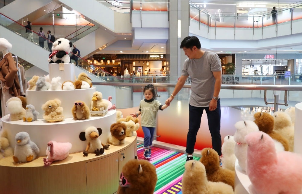 2023年11月2日，顧客在溫暖駝品牌專柜內(nèi)選購。連續(xù)六年參加進(jìn)博會(huì)的秘魯羊駝制品品牌溫暖駝在上海市中心商場開設(shè)了專柜。新華社記者 方喆 攝