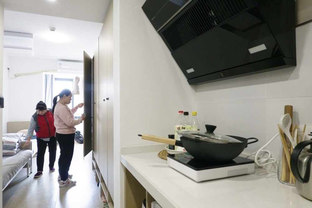 住戶在閔行區(qū)新時代城市建設(shè)者管理者之家收拾房間。