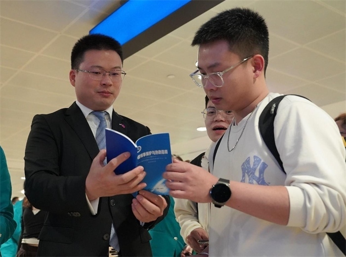 工作人員（左一）在發(fā)放《中國領(lǐng)事保護(hù)與協(xié)助指南》。 中國駐迪拜總領(lǐng)事館供圖