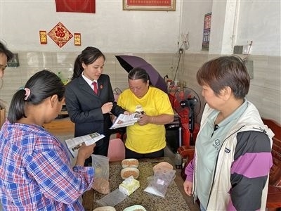  圖⑤：龍圩區(qū)法院法官到群眾家中開展法治宣傳。資料圖片