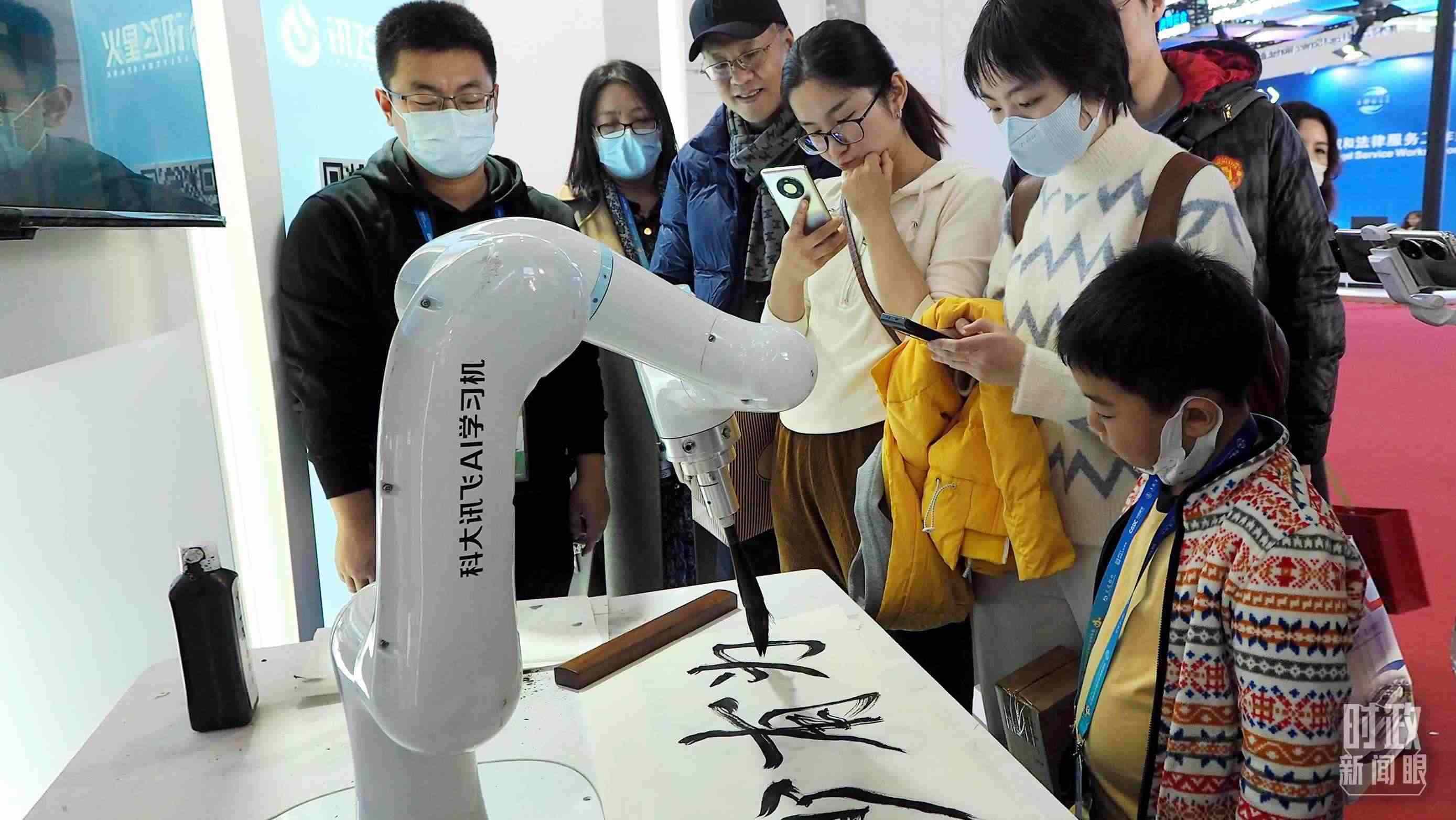△觀眾在首屆鏈博會(huì)上體驗(yàn)AI書法機(jī)器人。