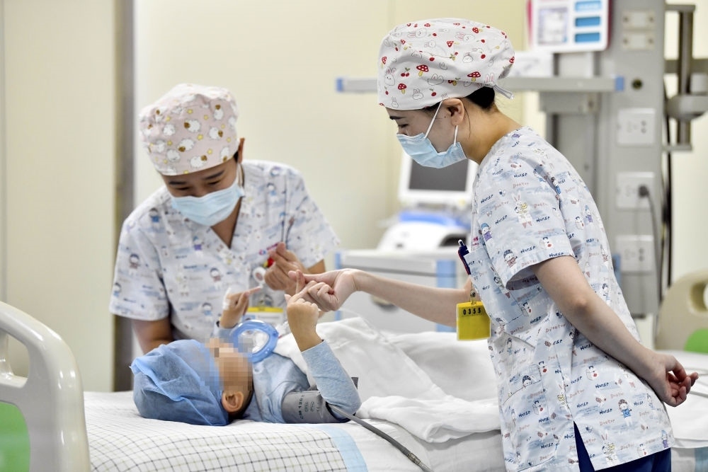 在山東省棗莊市婦幼保健院兒童ICU病房，醫(yī)護(hù)人員為完成靶向治療藥物諾西那生鈉的4歲脊髓性肌萎縮癥患兒加油鼓勁（2022年1月1日攝）。諾西那生鈉注射液是我國(guó)首個(gè)獲批治療脊髓性肌萎縮癥的進(jìn)口藥物，2019年進(jìn)入中國(guó)市場(chǎng)時(shí)，每針價(jià)格近70萬(wàn)元。在2021年國(guó)家醫(yī)保目錄藥品談判中，以3.3萬(wàn)元每針的價(jià)格進(jìn)入新版醫(yī)保藥品目錄。新華社記者 郭緒雷 攝