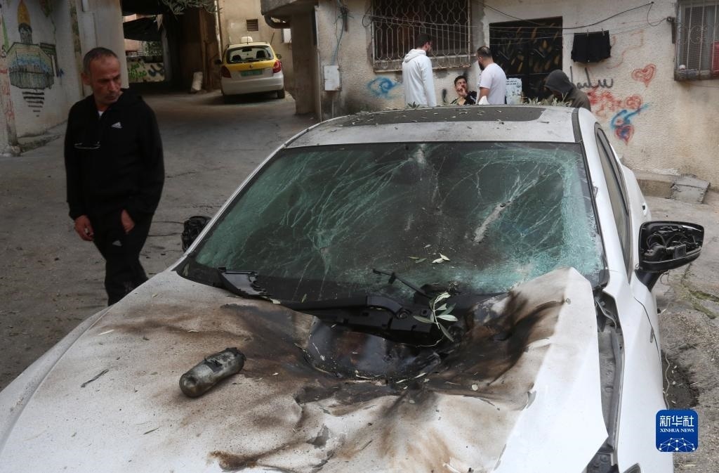 12月17日，在約旦河西岸城市圖勒凱爾姆附近的一處難民營(yíng)，人們查看在沖突中損毀的車輛。新華社發(fā)（尼達(dá)爾·艾仕塔耶?dāng)z）