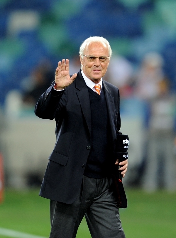 這是2010年7月7日，在南非德班舉行的2010年足球世界杯德國(guó)隊(duì)對(duì)陣西班牙隊(duì)的半決賽前，貝肯鮑爾接受電視臺(tái)采訪時(shí)和友人打招呼。新華社記者 王毓國(guó) 攝