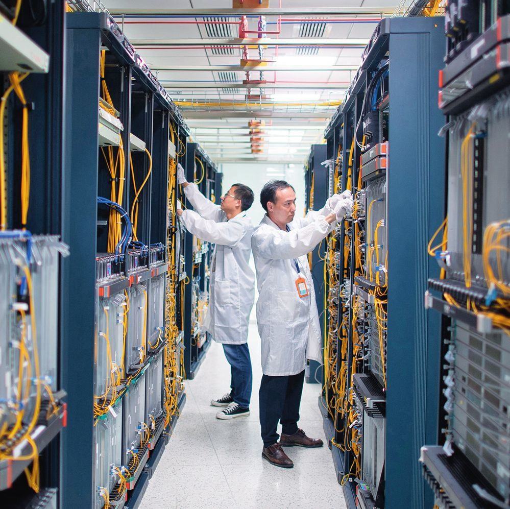 在位于武漢中國(guó)光谷的光電器件研發(fā)制造商——武漢光迅科技股份有限公司生產(chǎn)車(chē)間內(nèi)，技術(shù)人員在光模塊生產(chǎn)線作業(yè)（2023年4月11日攝）。程敏攝/本刊