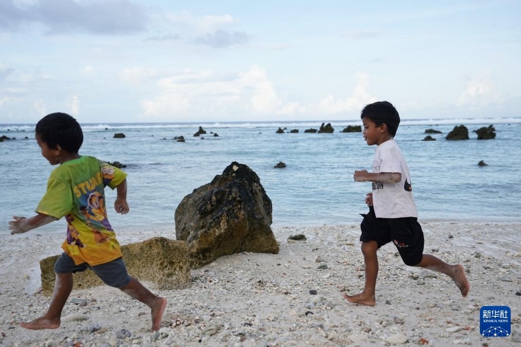 1月20日，兒童在瑙魯海邊嬉戲。新華社記者 王申 攝