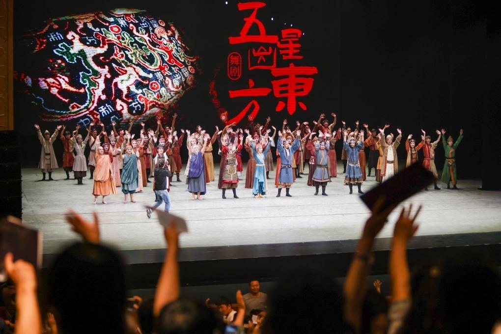 2023年7月31日，新疆和田地區(qū)新玉歌舞團(tuán)在烏魯木齊京劇院演出舞劇《五星出東方》后和觀眾互相揮手致意。這場演出是第六屆中國新疆國際民族舞蹈節(jié)的參演劇目之一，曾榮獲國家“文華獎”等。新華社記者 郝昭 攝