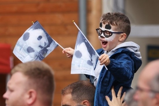  2023年7月26日，在法國(guó)圣艾尼昂市博瓦勒野生動(dòng)物園外，一名兒童等待送別熊貓“圓夢(mèng)”。新華社記者 高靜 攝
