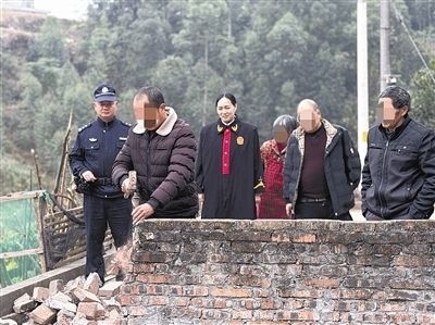  圖③：庭審結(jié)束后，在法官的見(jiàn)證下，陳某在院壩邊重新開(kāi)鑿一條通道。