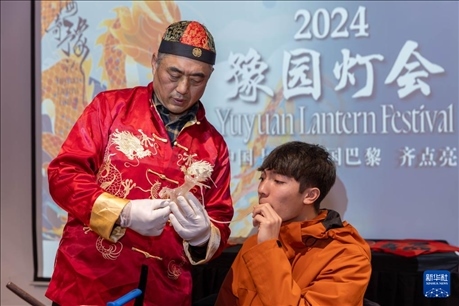 1月28日，在上海豫園舉行的民俗活動上，美國馬斯卡廷中學學生在非遺傳承人的指導下吹糖偶。 新華社記者 王翔 攝