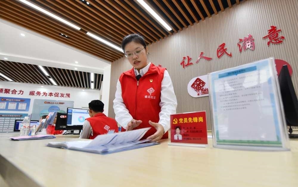 △2023年12月14日，廣西南寧市蟠龍社區(qū)，工作人員在為居民服務(wù)。