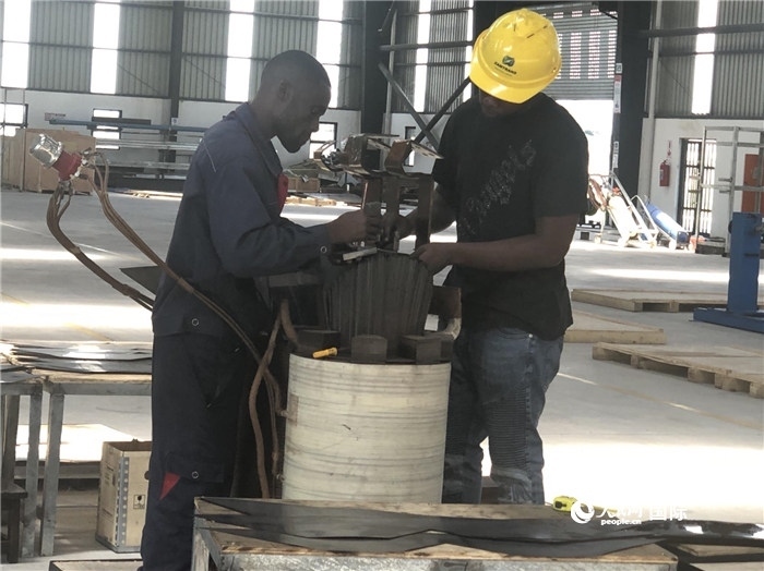 經(jīng)貿(mào)合作區(qū)廠房內(nèi)，當?shù)毓と苏诰o張作業(yè)。人民網(wǎng)記者 黃培昭攝