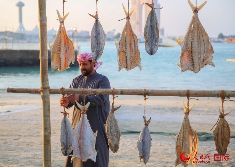  手工藝者展示如何晾曬魚干。人民網(wǎng) 塔里克·易卜拉欣攝