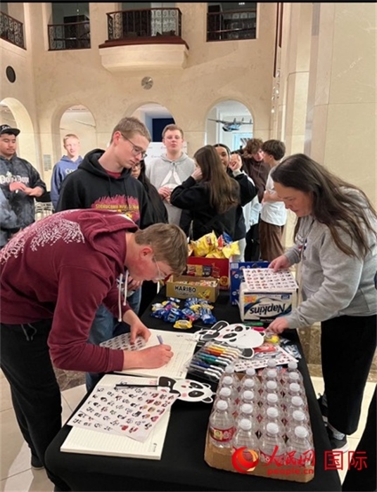 學(xué)生們出發(fā)前紛紛在留言簿留言。人民網(wǎng)記者 鄧圩攝