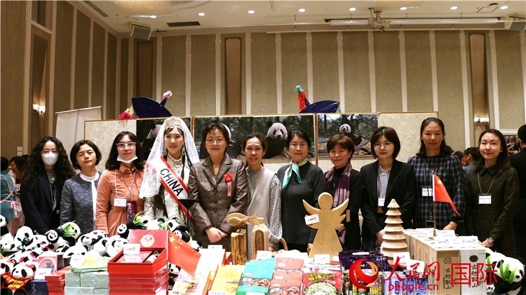 中國(guó)駐日本大使吳江浩夫人丁玥（左五）與使館人員在展位前合影留念。人民網(wǎng) 許可攝