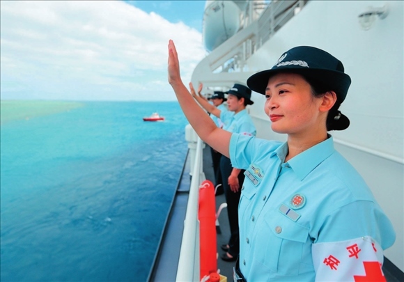 中國(guó)海軍“和平方舟”號(hào)醫(yī)院船結(jié)束訪問(wèn)湯加時(shí)，任務(wù)官兵中的文職人員向歡送人群揮手告別（2023年8月4日攝）。徐巍攝/本刊