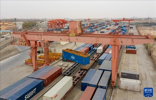 4月21日，二連浩特鐵路口岸龍門(mén)吊吊裝中歐班列集裝箱（無(wú)人機(jī)照片）。 新華社發(fā)（張海峰攝）