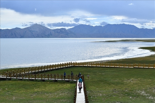 △ 游客行走在青?，敹嗫h冬格措納湖畔的木棧道上。
