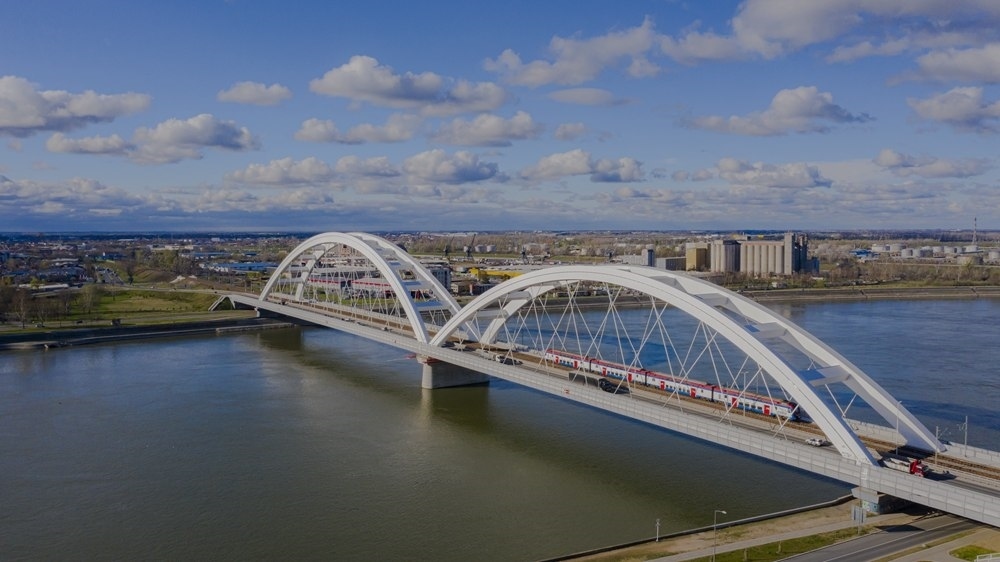 2024年3月12日，一列火車運(yùn)行在匈塞鐵路塞爾維亞境內(nèi)貝諾段諾維薩德多瑙河大橋上（無(wú)人機(jī)照片）。新華社發(fā)（任衛(wèi)云攝）