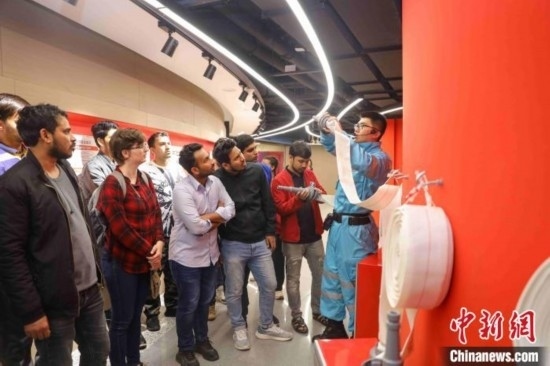 5月9日，工作人員指導(dǎo)留學(xué)生正確使用消防水帶。張鷹 攝