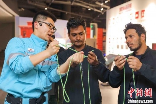 5月9日，工作人員指導(dǎo)留學(xué)生學(xué)習(xí)打繩結(jié)。張鷹 攝