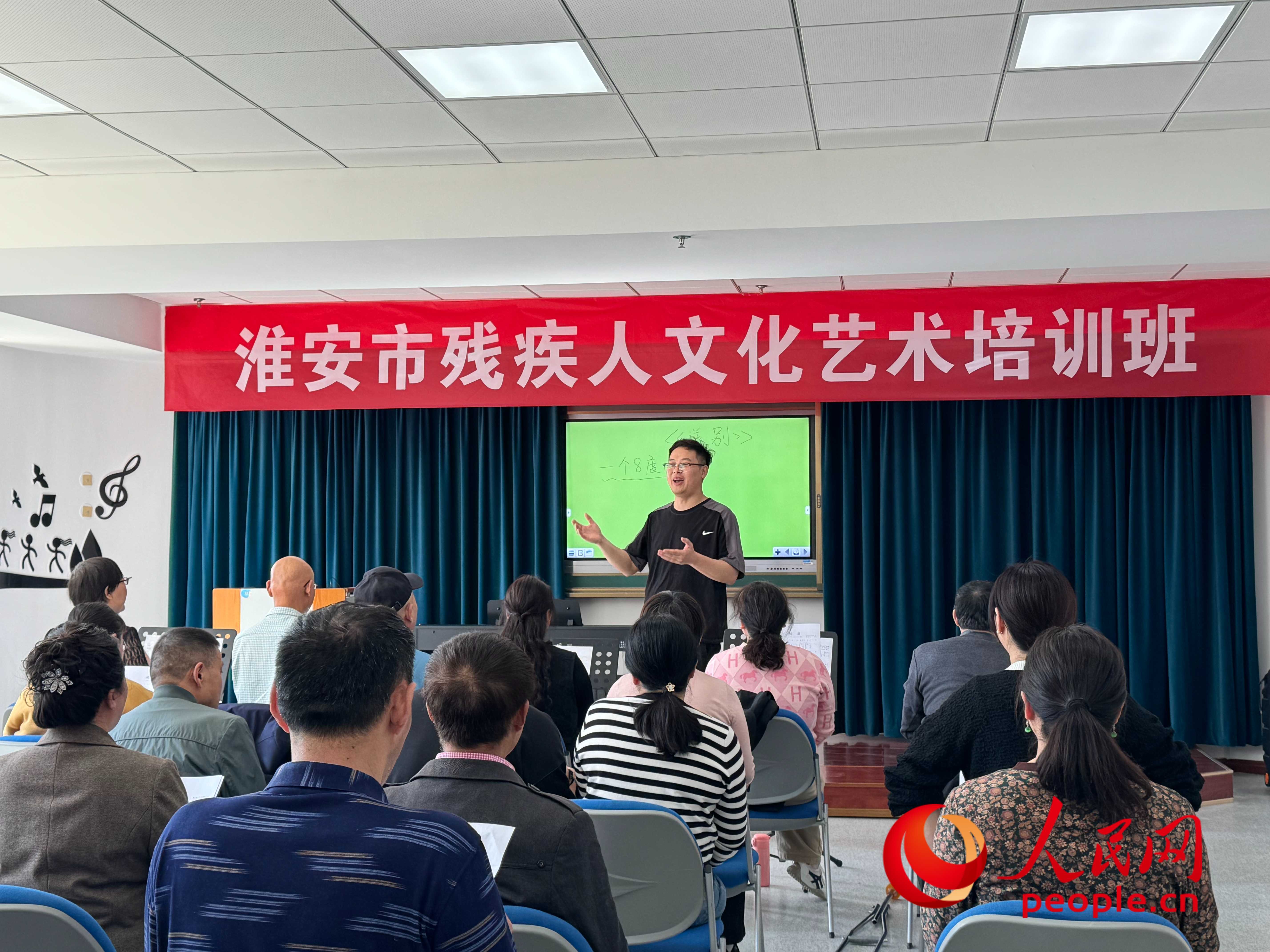 在淮安市殘疾人文化藝術(shù)培訓班上，聲樂老師在教殘疾人唱《送別》這首歌曲。人民網(wǎng) 周靜圓攝