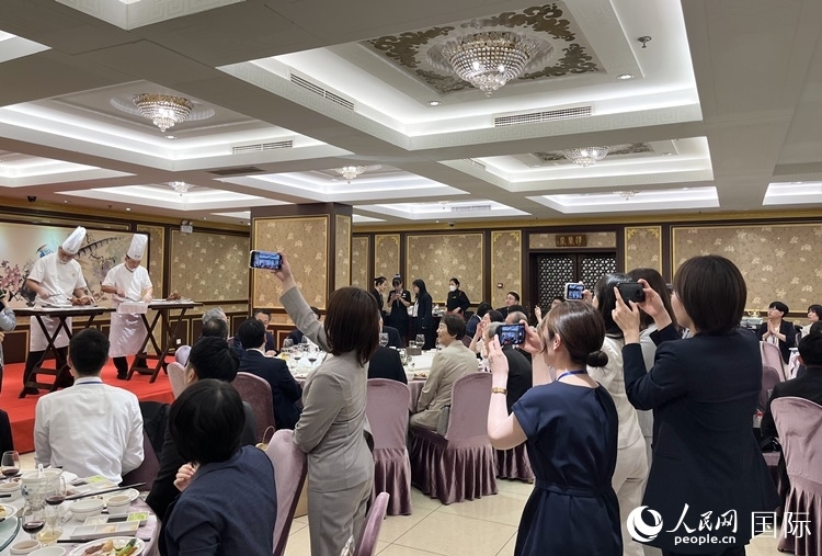 國家級非物質(zhì)文化遺產(chǎn)、全聚德片鴨工藝吸引代表團成員拍照留念。