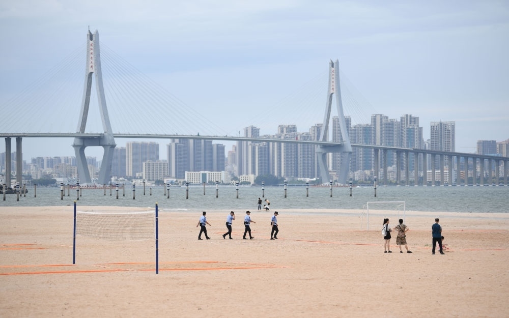 2023年7月17日，廣東湛江五環(huán)廣場的沙灘上，公安民警在執(zhí)勤巡邏。新華社記者 鄧華 攝