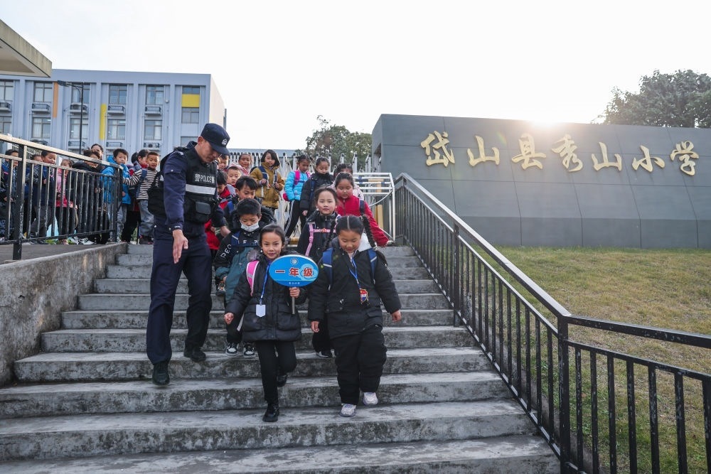 2023年12月20日，秀山派出所民警在秀山小學(xué)放學(xué)時間參與“護學(xué)崗”維持秩序，同時接獨自放學(xué)的學(xué)生去“民生小鋪”。浙江省舟山市岱山縣公安局秀山派出所聯(lián)合鄉(xiāng)鎮(zhèn)、社區(qū)成立“民生小鋪”，為當?shù)鼐用?、外來?wù)工人員及其子女等服務(wù)，協(xié)助解決外來務(wù)工人員在工作、生活等方面的矛盾和問題，助力鄉(xiāng)鎮(zhèn)基層治理。新華社記者 徐昱 攝
